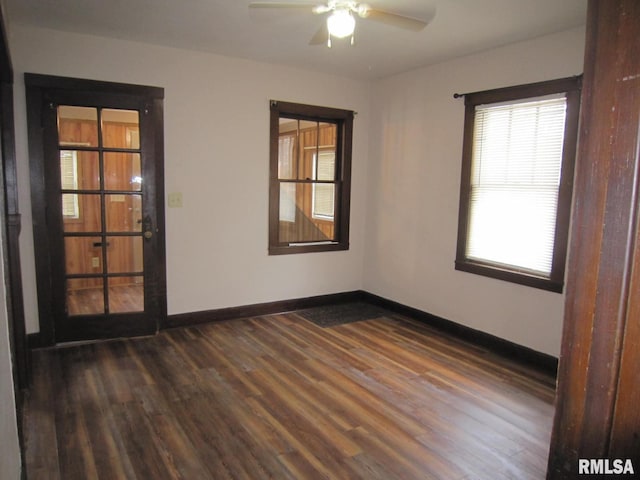 empty room featuring dark wood-style floors, baseboards, and a ceiling fan