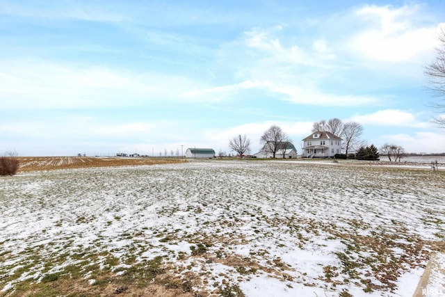 snowy yard featuring a rural view