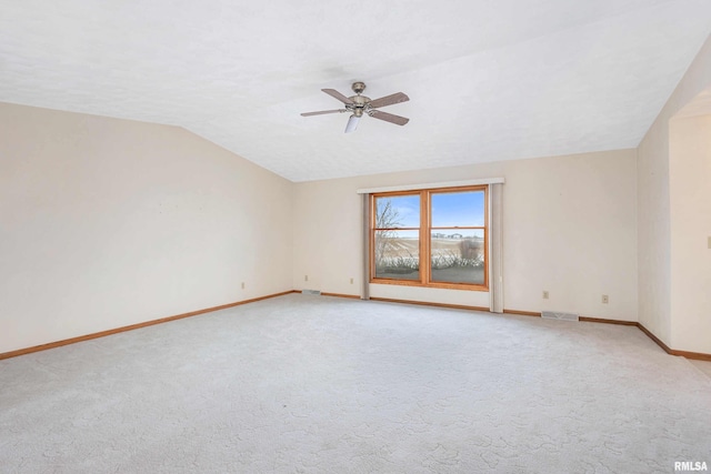 carpeted empty room featuring vaulted ceiling and ceiling fan