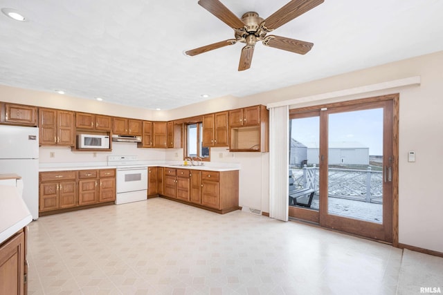 kitchen with white appliances, ceiling fan, and sink