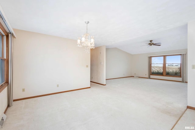 carpeted empty room with ceiling fan with notable chandelier and vaulted ceiling