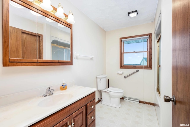 full bathroom featuring vanity, toilet, and bath / shower combo with glass door