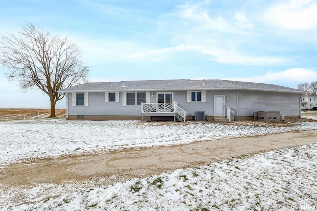 snow covered property with central air condition unit