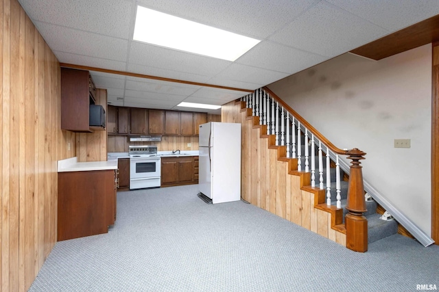 kitchen featuring a drop ceiling, light colored carpet, white appliances, and sink