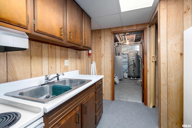 kitchen featuring wood walls, a drop ceiling, water heater, and electric water heater