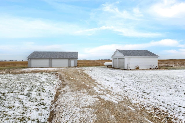 snow covered structure featuring a garage