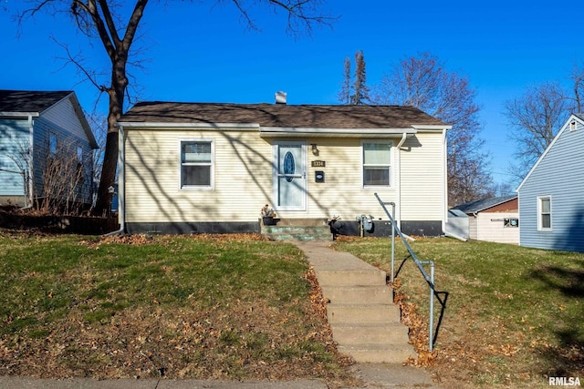 bungalow-style house featuring a front lawn