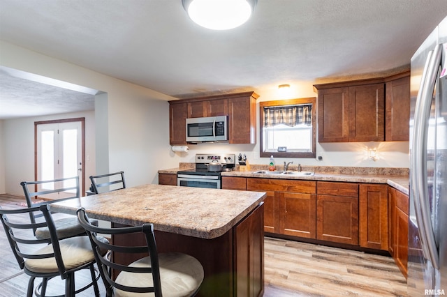 kitchen with plenty of natural light, sink, light wood-type flooring, and stainless steel appliances