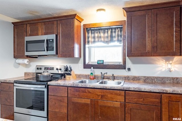 kitchen featuring a textured ceiling, sink, and stainless steel appliances