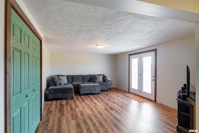 living room with a textured ceiling and dark hardwood / wood-style flooring