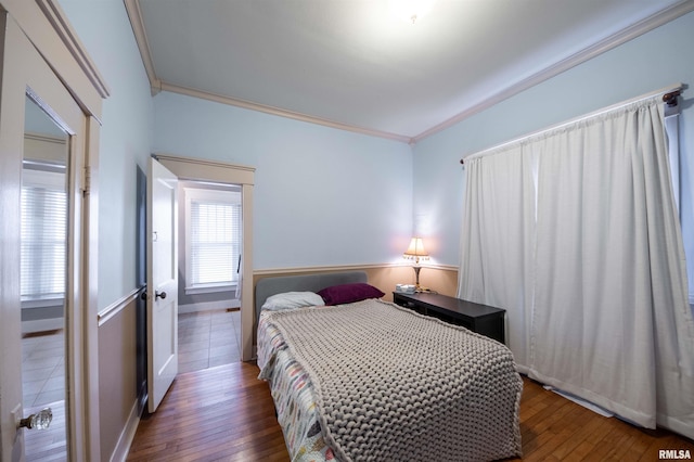 bedroom with crown molding and dark wood-type flooring