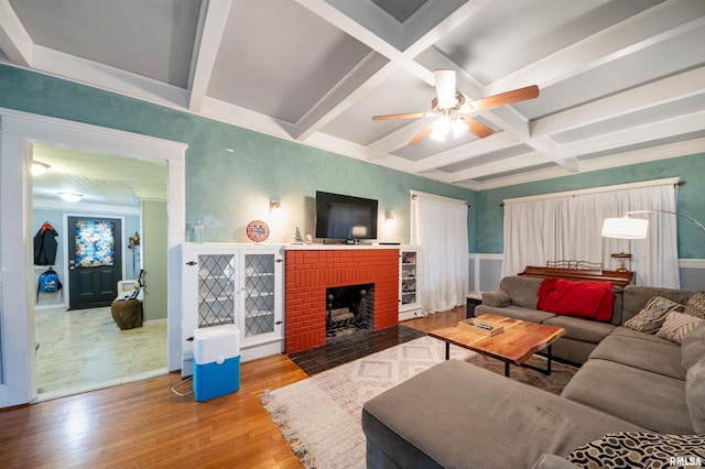 living room with hardwood / wood-style floors, coffered ceiling, a brick fireplace, ceiling fan, and beam ceiling