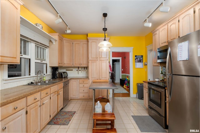 kitchen featuring decorative light fixtures, light brown cabinets, stainless steel appliances, and track lighting