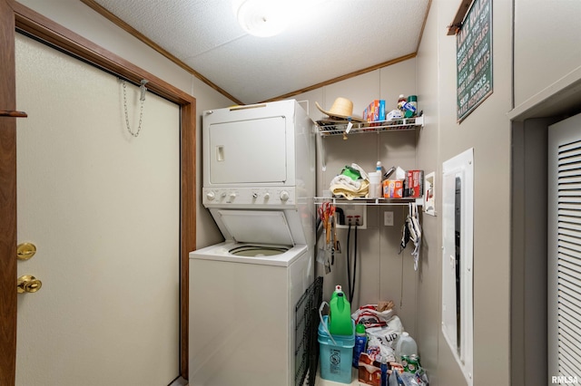 washroom featuring stacked washer and dryer, a textured ceiling, and ornamental molding