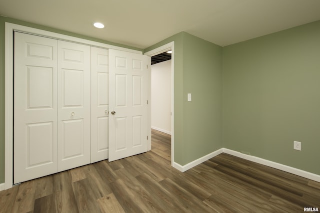 unfurnished bedroom featuring dark hardwood / wood-style flooring and a closet