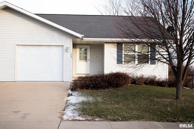 view of front facade with a garage, concrete driveway, a front lawn, and roof with shingles