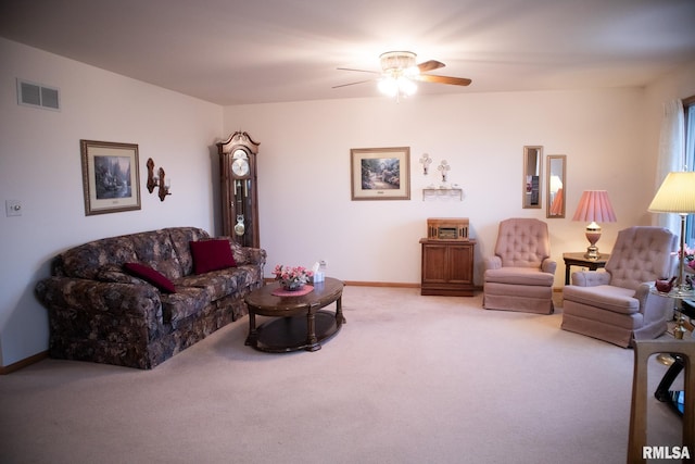 living room with baseboards, a ceiling fan, visible vents, and light colored carpet