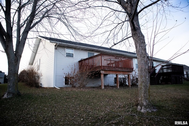 back of property with a deck and a yard