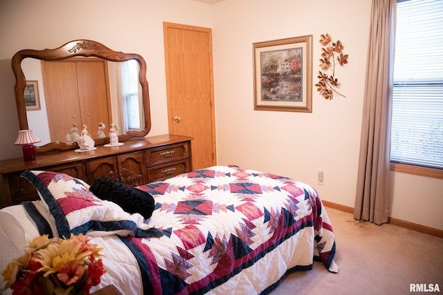 bedroom featuring light carpet and baseboards