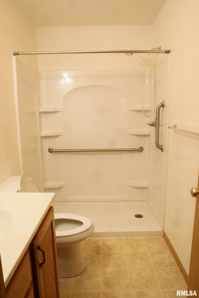 full bathroom with tile patterned floors, vanity, toilet, and walk in shower