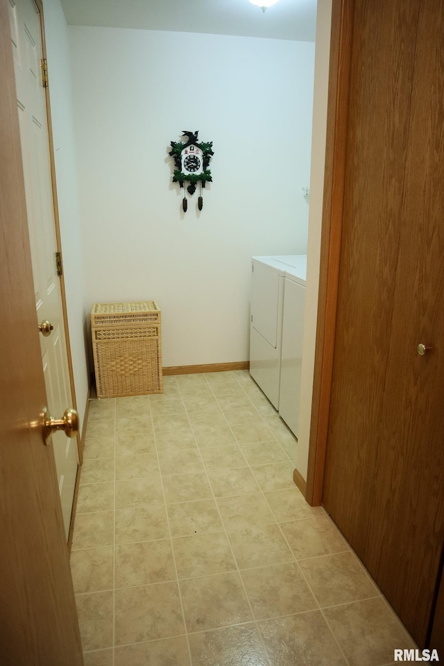 interior space with light tile patterned floors, laundry area, independent washer and dryer, and baseboards