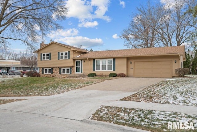 tri-level home with a garage and a front yard