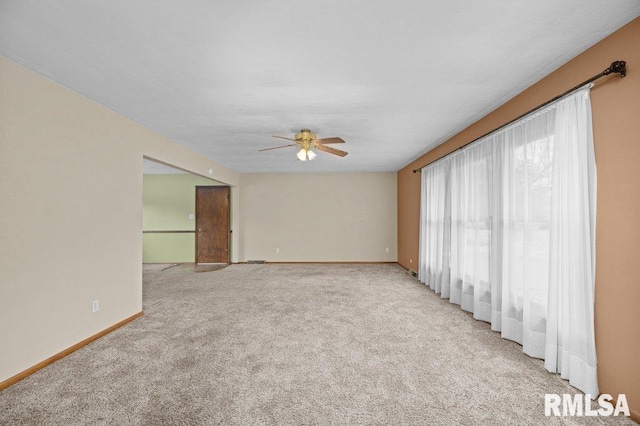 spare room with light colored carpet and ceiling fan