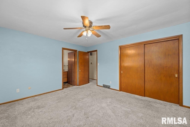 unfurnished bedroom with light carpet, a closet, ceiling fan, and ensuite bathroom