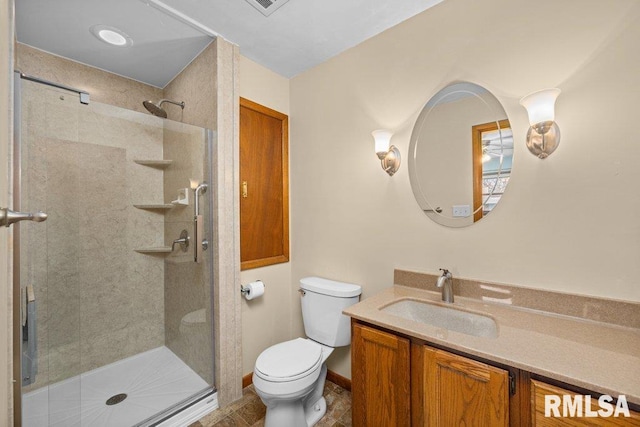 bathroom with vanity, a shower with shower door, and toilet