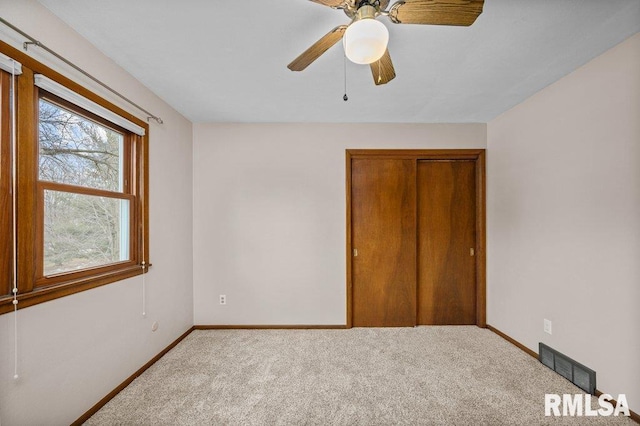 unfurnished bedroom featuring ceiling fan, carpet floors, and a closet