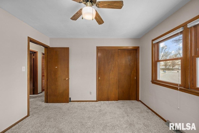 unfurnished bedroom with ceiling fan, light colored carpet, and a closet