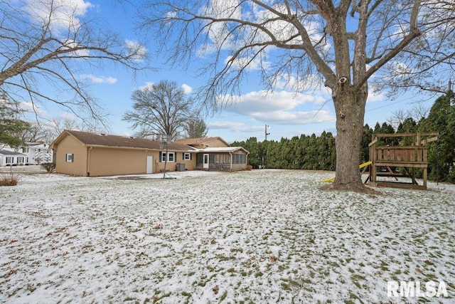 snow covered property with a sunroom