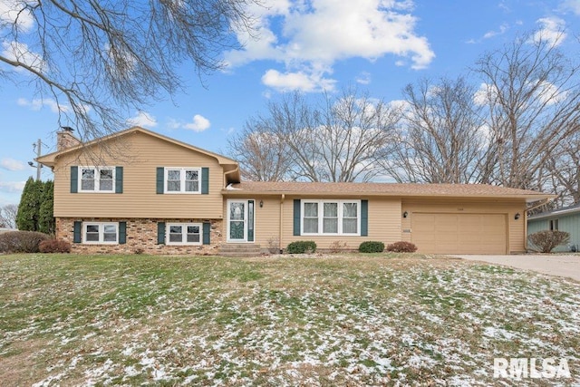 split level home featuring a garage and a front yard