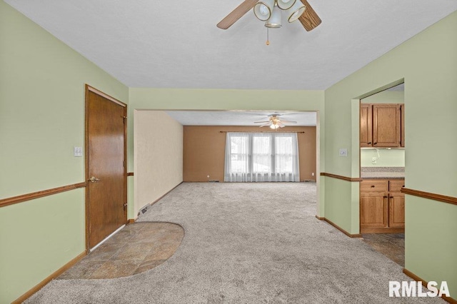 empty room featuring ceiling fan and light colored carpet