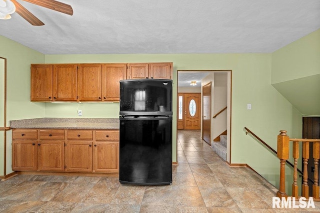 kitchen with ceiling fan, black fridge, and a textured ceiling