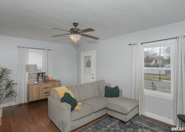 living room with ceiling fan and dark wood-type flooring