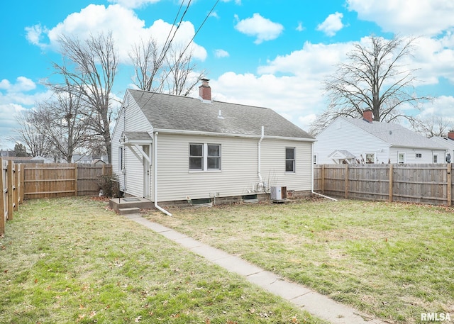 rear view of house with cooling unit and a lawn