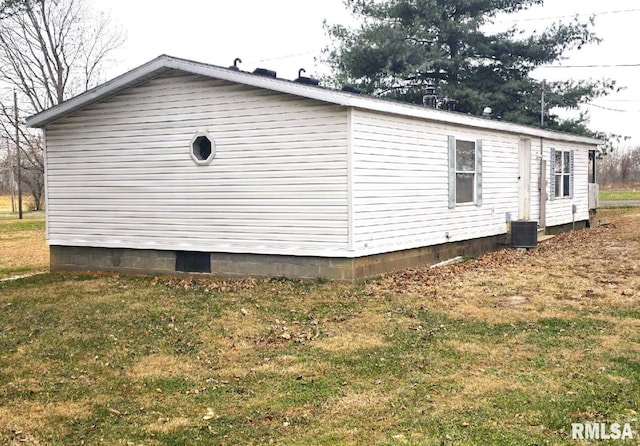 view of side of home with cooling unit and a lawn