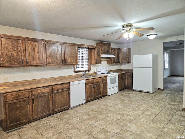 kitchen with a textured ceiling, ceiling fan, sink, and white appliances