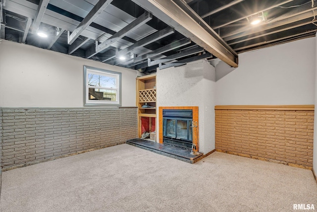 basement with carpet flooring and brick wall