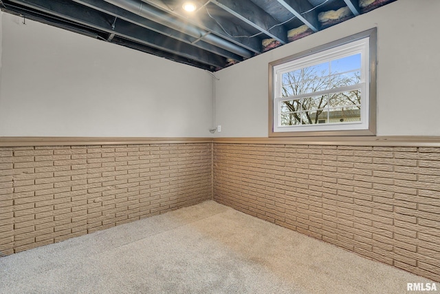 basement with carpet flooring and brick wall