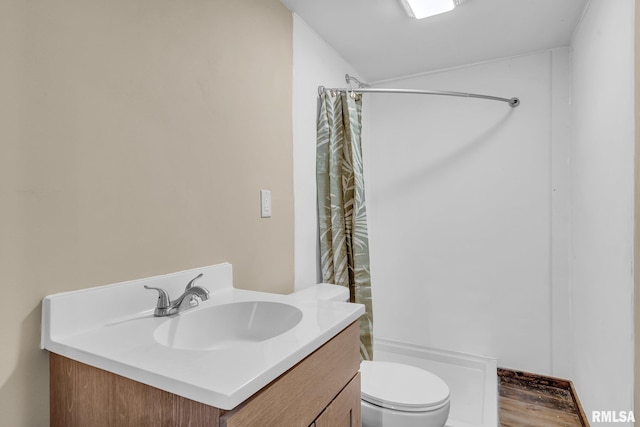 bathroom featuring vanity, toilet, wood-type flooring, and walk in shower