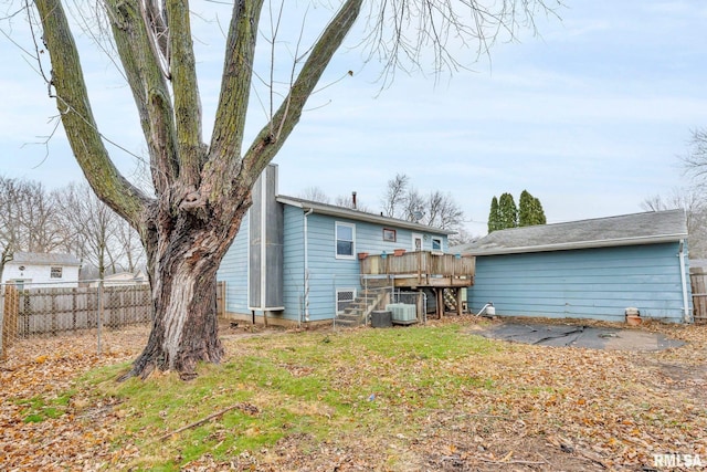 back of property featuring a yard, cooling unit, and a deck