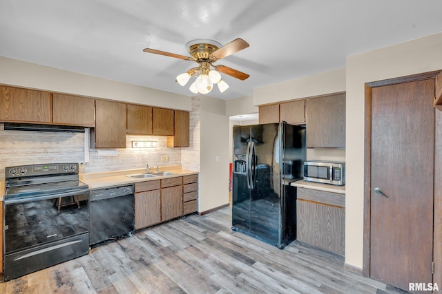 kitchen with black appliances, sink, light hardwood / wood-style flooring, ceiling fan, and decorative backsplash