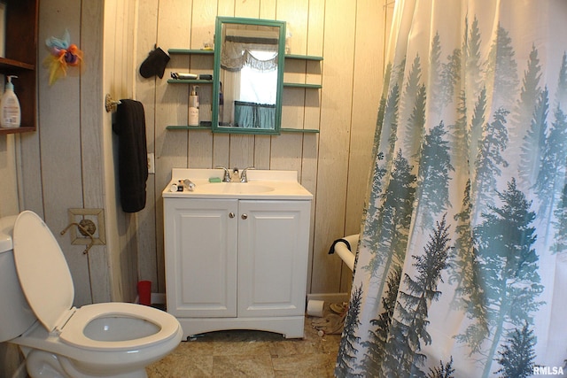 bathroom with vanity, toilet, a shower with curtain, and wooden walls