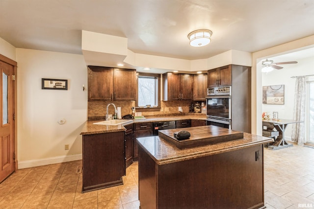 kitchen featuring a center island, backsplash, sink, dark brown cabinetry, and stainless steel double oven