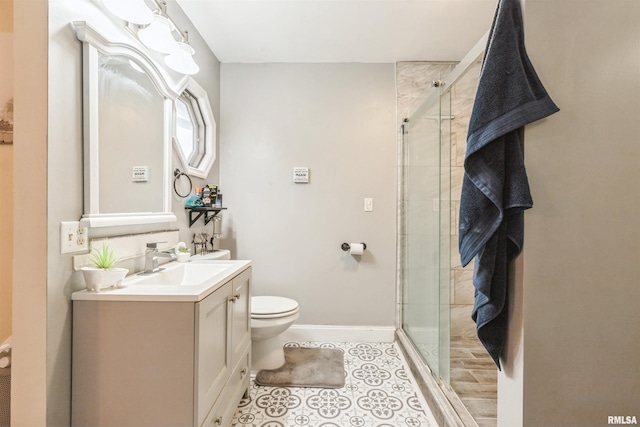 bathroom featuring vanity, toilet, and a shower with shower door