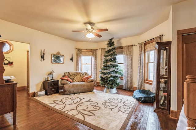 living room featuring ceiling fan and dark wood-type flooring