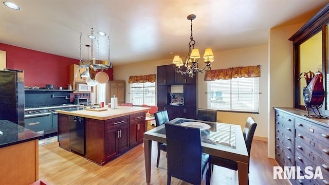 kitchen featuring plenty of natural light, a kitchen island, black appliances, and a notable chandelier