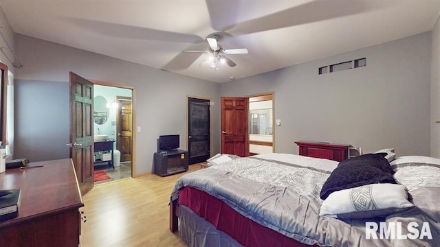 bedroom featuring ceiling fan, light wood-type flooring, and ensuite bathroom